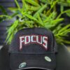 Black cap with "FOCUS" embroidered in red, white, and blue.